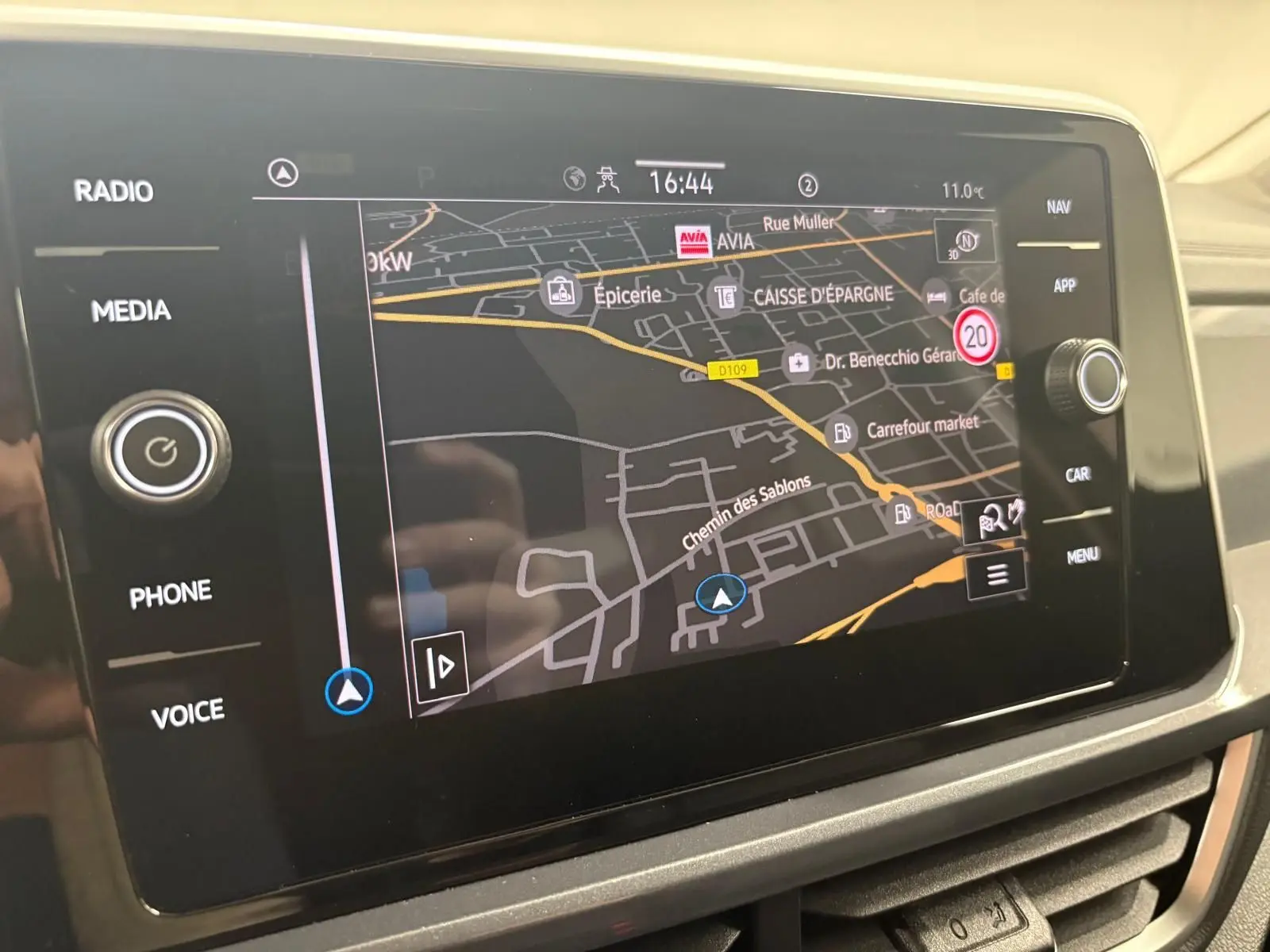 Écran tactile central du Volkswagen T-Roc 2025 affichant la navigation GPS avec commandes autour.