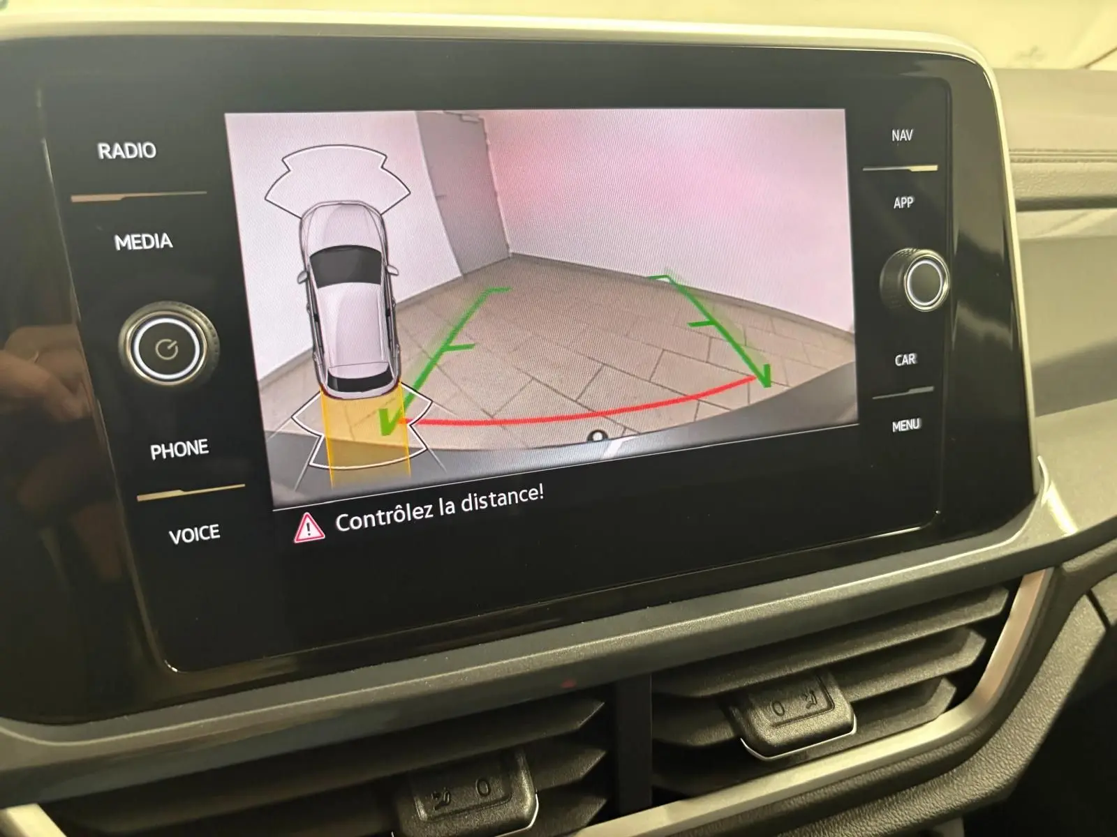 Écran central montrant la caméra de recul avec guidage dynamique du Volkswagen T-Roc 2025 en Gris Indium.