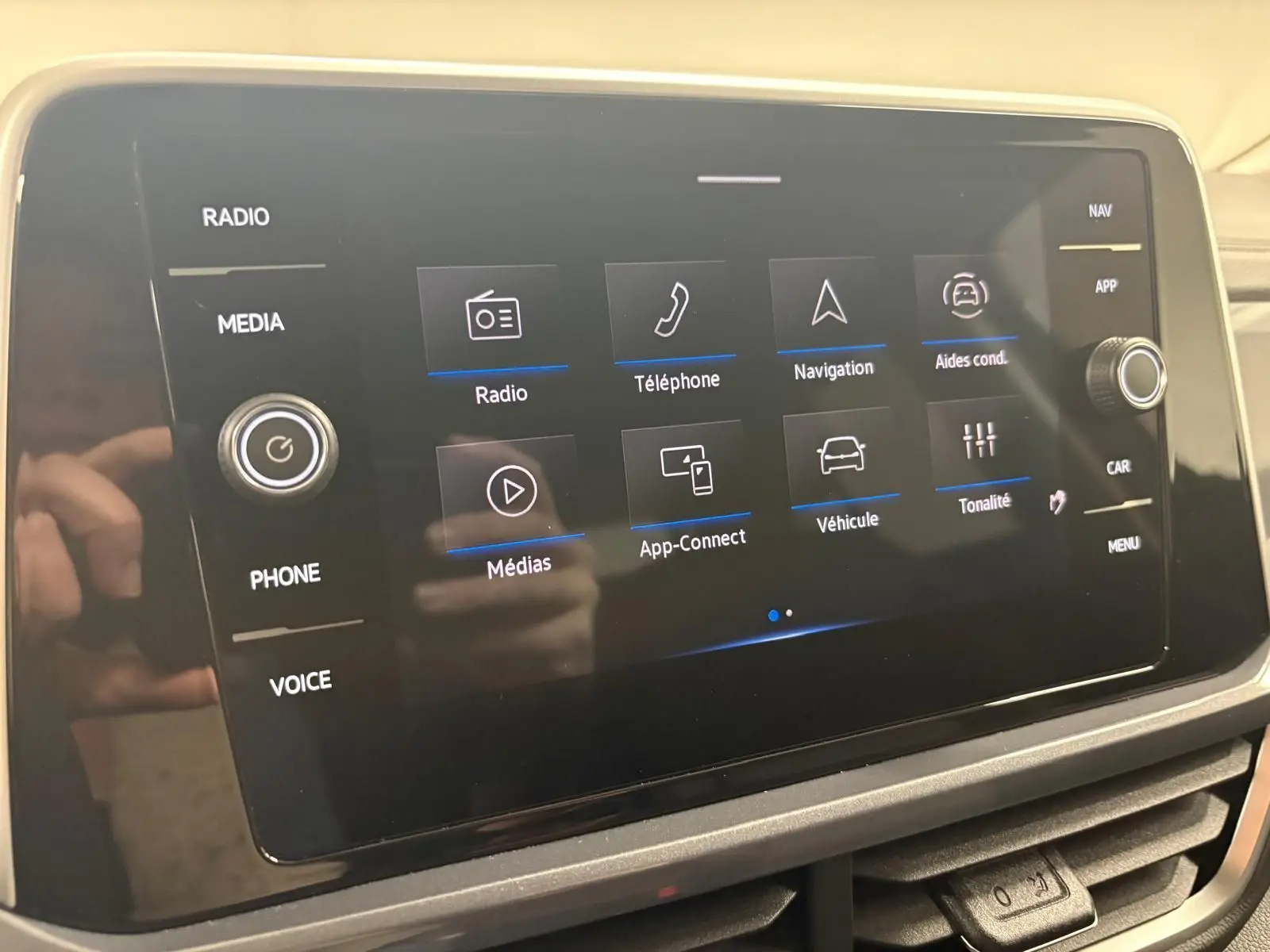 Écran tactile central du Volkswagen T-Roc 2025 affichant les options radio, téléphone, navigation et aides à la conduite.