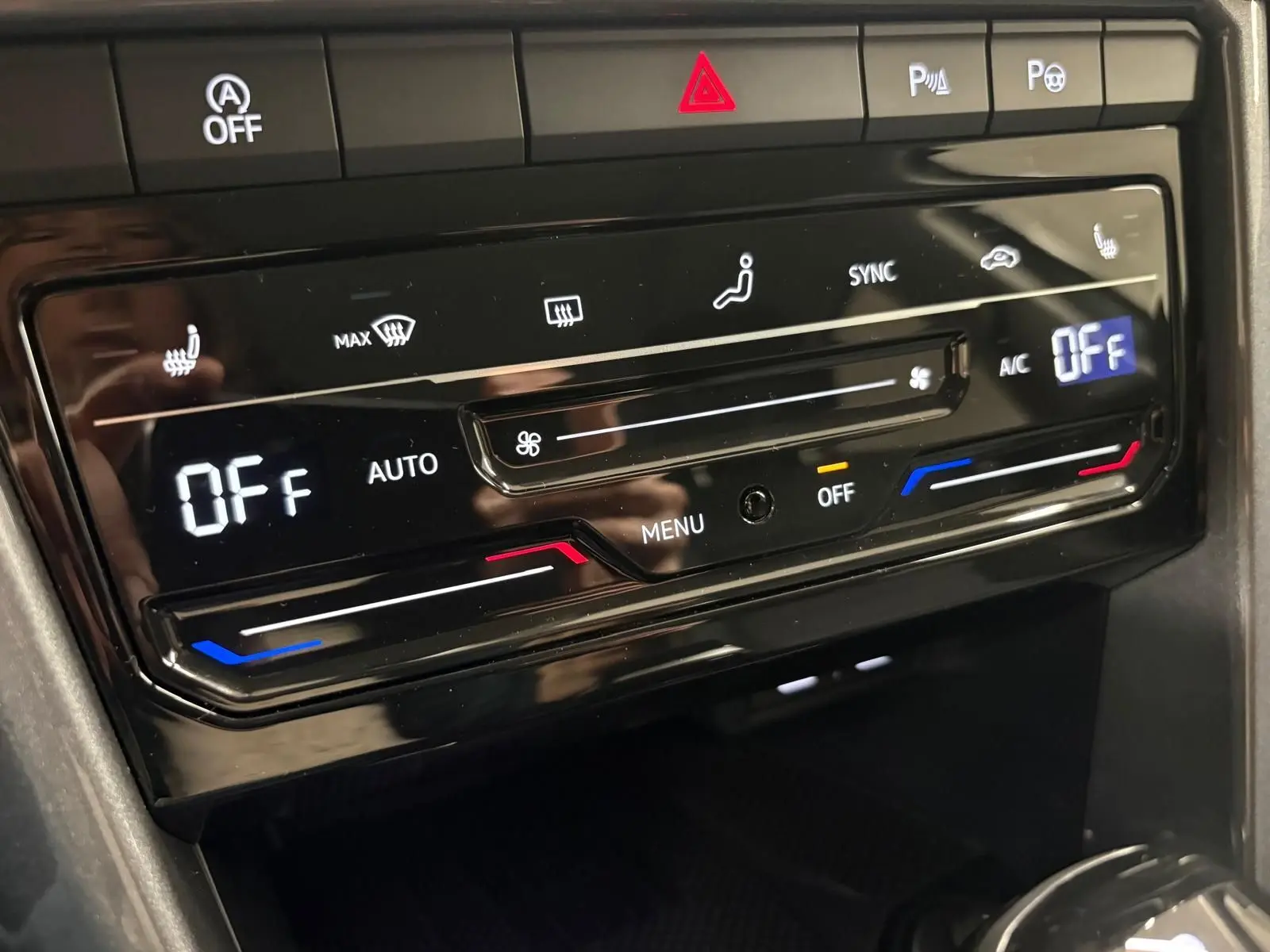 Gros plan sur la commande de climatisation digitale du Volkswagen T-Roc 2025 en finition Style Exclusive, intérieur noir brillant.