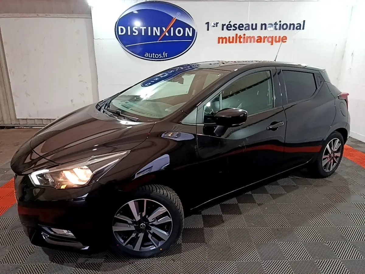 Nissan Micra IG-T 90 N-Connecta noire vue 3/4 avant droit, phares allumés, jantes alliage et rétroviseurs noirs.