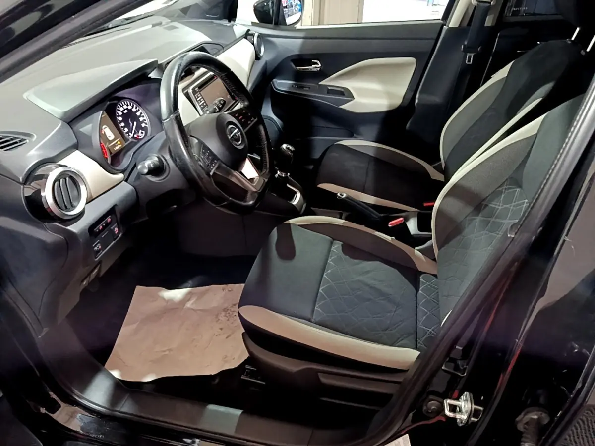 Intérieur avant droit de la Nissan Micra IG-T 90 N-Connecta 2017 noire, volant cuir multifonctions et tableau de bord tactile.