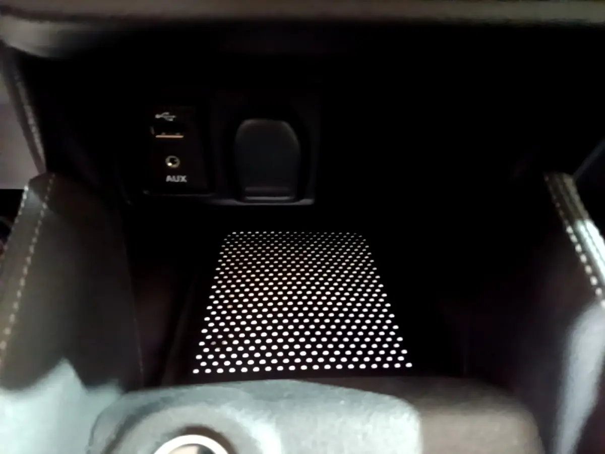 Gros plan sur la console centrale noire de la Nissan Micra IG-T 90 N-Connecta avec prise USB et port AUX visibles.