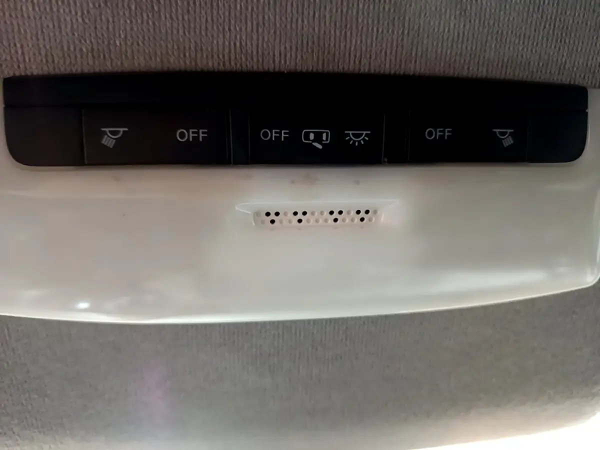 Vue rapprochée du plafonnier gris clair avec boutons de commande d’éclairage dans une Nissan Micra noire 2017.