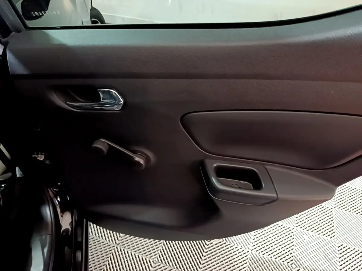 Vue intérieure côté gauche de la porte arrière noire de la Nissan Micra 2017 avec poignée chromée et manivelle de vitre.