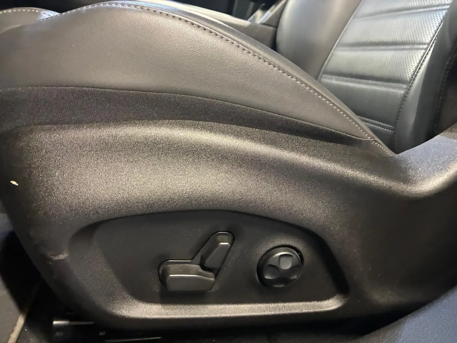 Détail des commandes de réglage électrique du siège conducteur en cuir noir de l'Alfa Romeo Tonale 2022.