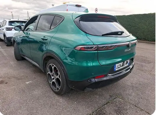 Vue frontale d'une Alfa Romeo Tonale 1.5 MHEV vert foncé, avec calandre emblématique en V et phares LED triples.