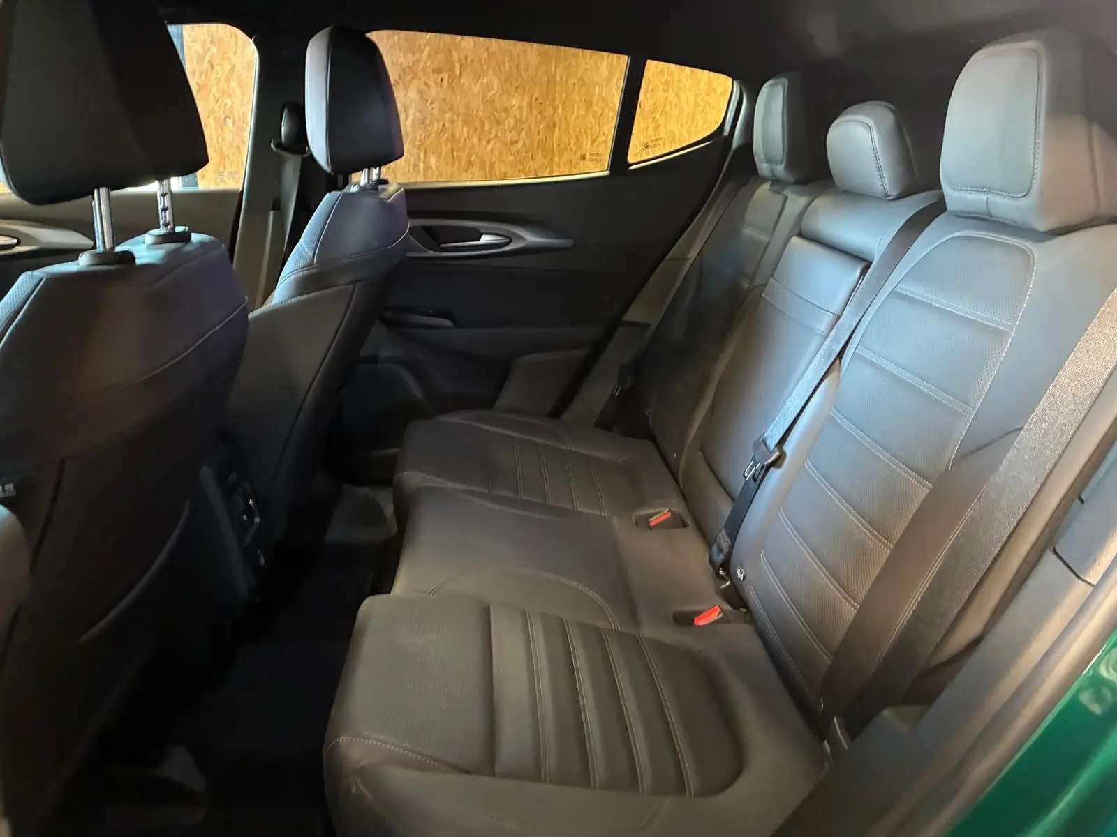 Vue intérieure côté droit des sièges arrière en cuir noir de l'Alfa Romeo Tonale vert foncé 2022.