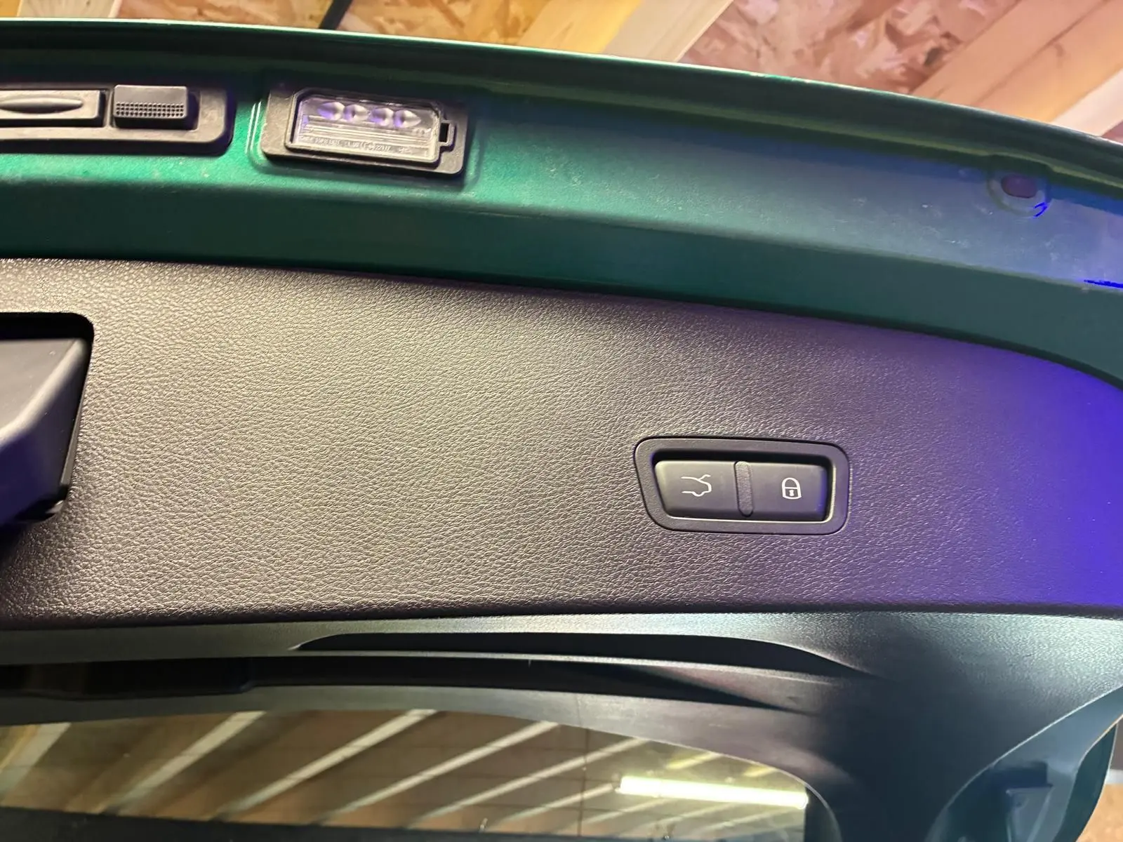 Détail intérieur du hayon vert foncé d'une Alfa Romeo Tonale 2022, avec boutons de fermeture et verrouillage intégrés.