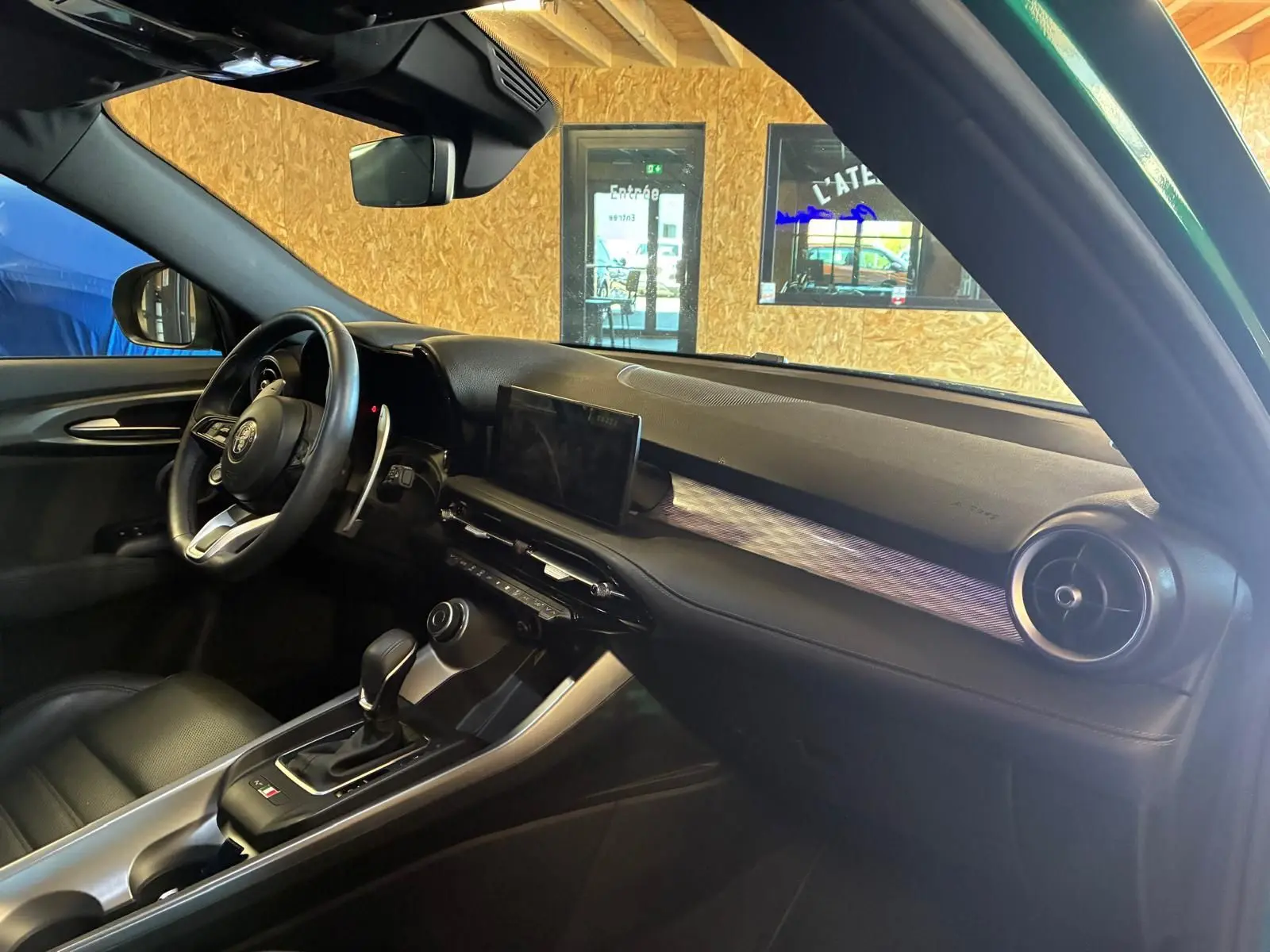 Intérieur noir de l'Alfa Romeo Tonale 1.5 MHEV 2022, vue côté conducteur sur tableau de bord et console centrale.