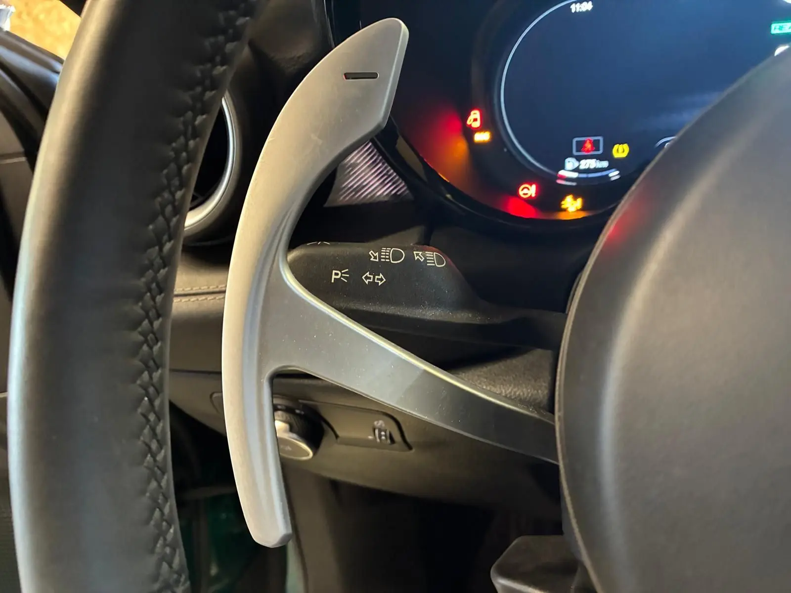 Gros plan sur la palette de changement de vitesse grise côté gauche du volant d’un Alfa Romeo Tonale 2022, intérieur noir.