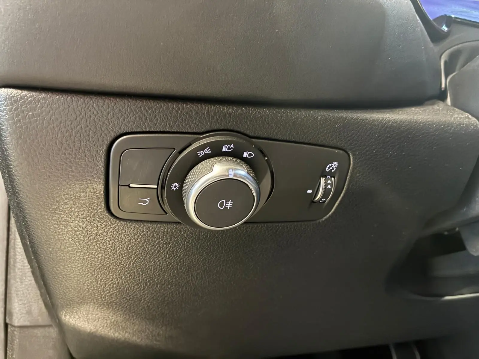 Gros plan sur le bouton de commande des feux et réglage de luminosité dans l'Alfa Romeo Tonale 1.5 MHEV 130 TCT7 Edizione Speciale.