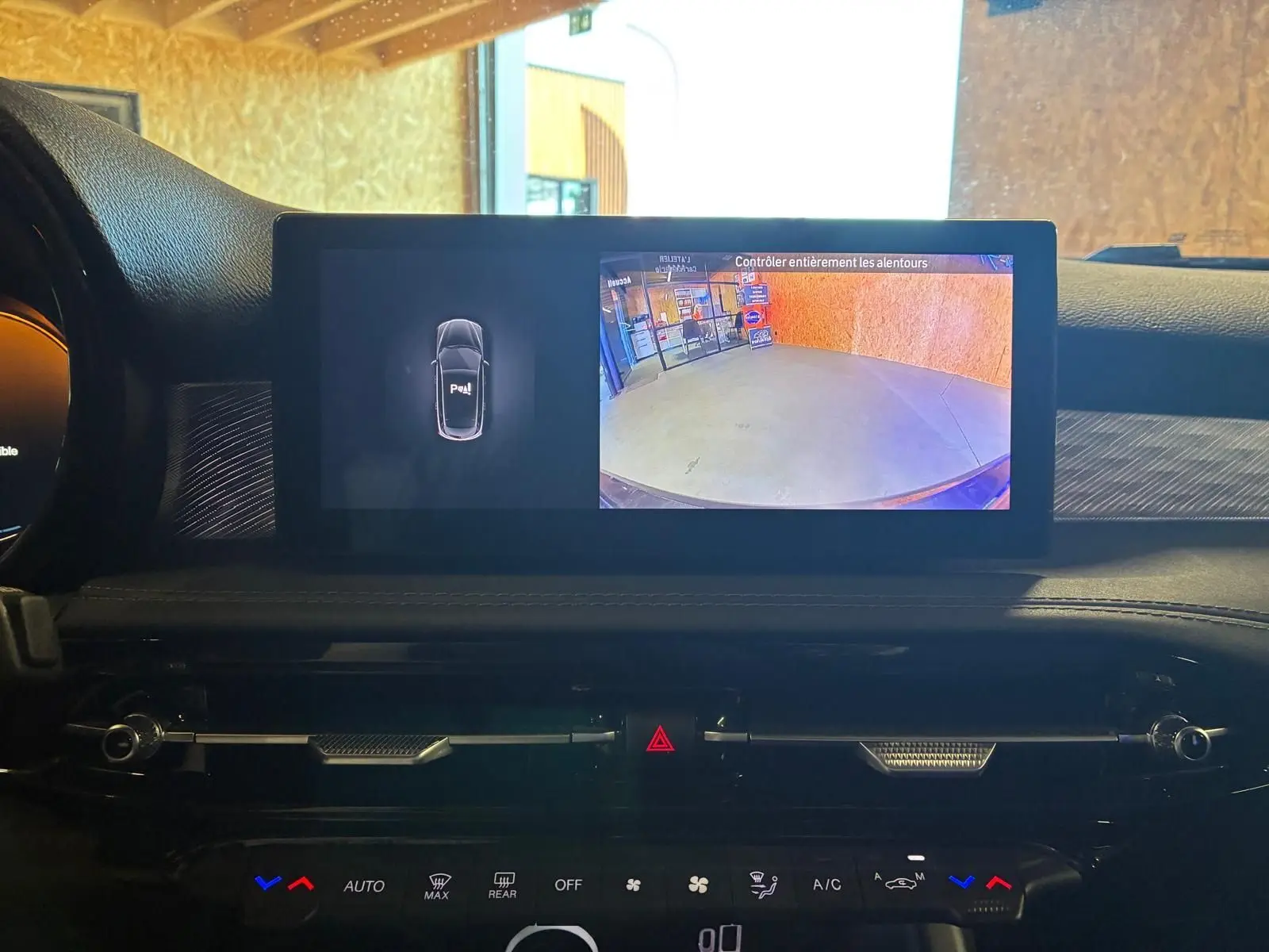 Écran central de l'Alfa Romeo Tonale 2022 affichant la caméra de recul et l'aide au stationnement, intérieur noir.