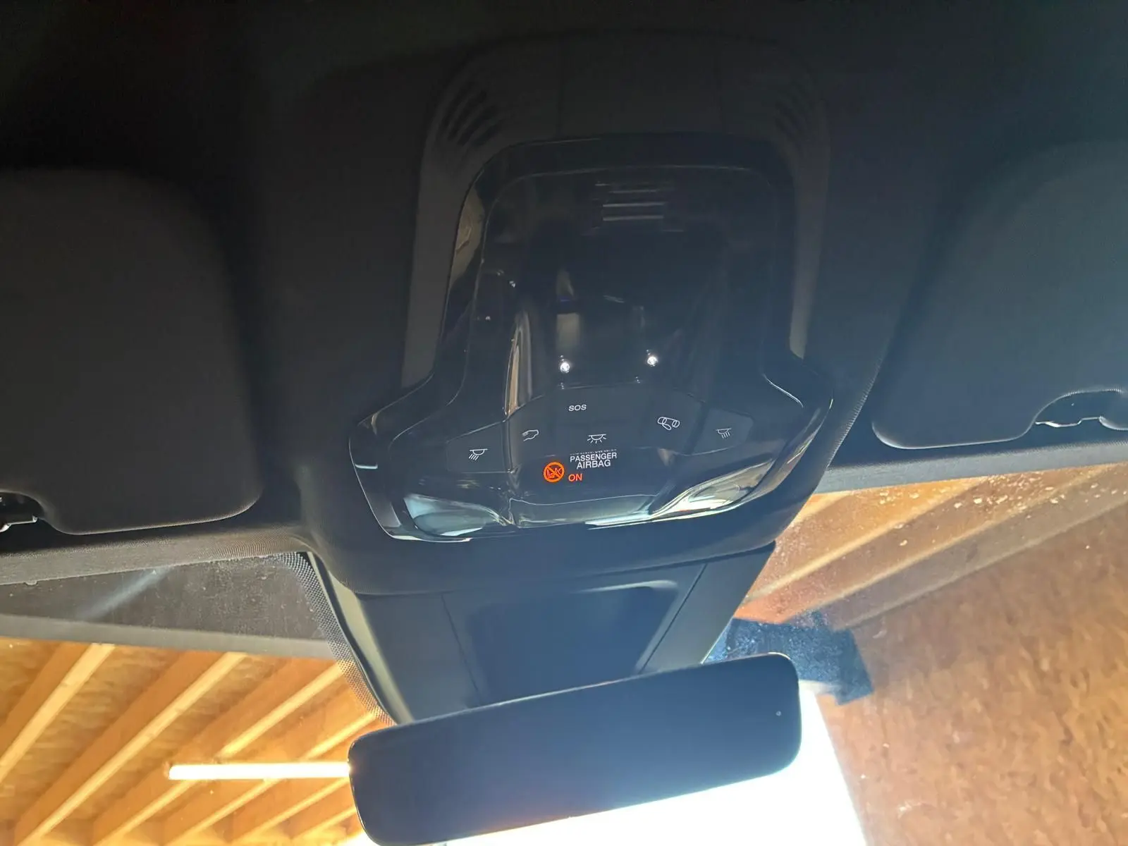 Vue intérieure en plongée du plafonnier et du rétroviseur d'un Alfa Romeo Tonale vert foncé, avec indicateur airbag passager allumé.