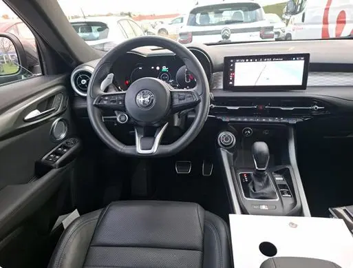 Vue 3/4 arrière droite de l'Alfa Romeo Tonale vert foncé, avec feux arrière fins et jantes distinctives en cercle.