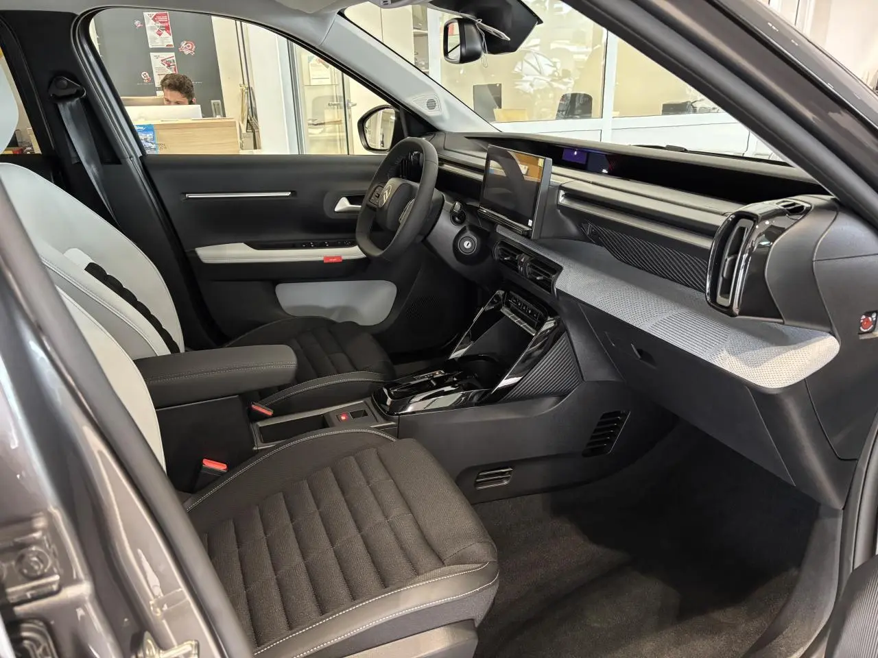Vue intérieure côté conducteur du Citroën C3 Aircross 2026 gris et noir, avec tableau de bord moderne et écran tactile central.