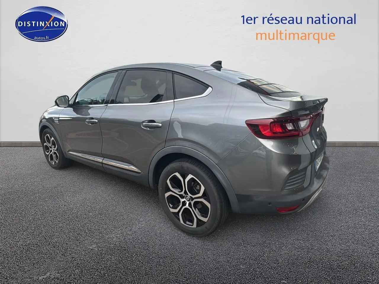 Vue 3/4 arrière droite d’un Renault Arkana gris avec jantes alliage et vitres teintées sur fond neutre.
