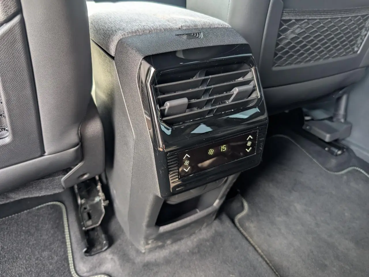 Vue rapprochée de la console centrale arrière noire avec commandes de climatisation digitale du Peugeot 5008 blanc 2025.
