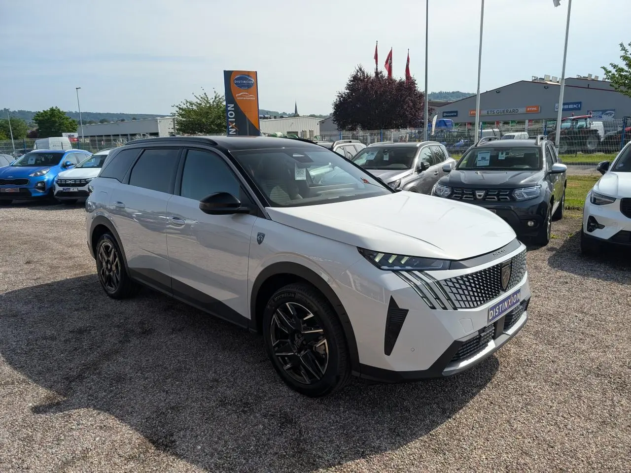 Peugeot 5008 blanc vue 3/4 avant droit, avec toit noir et jantes alliage noires brillantes.