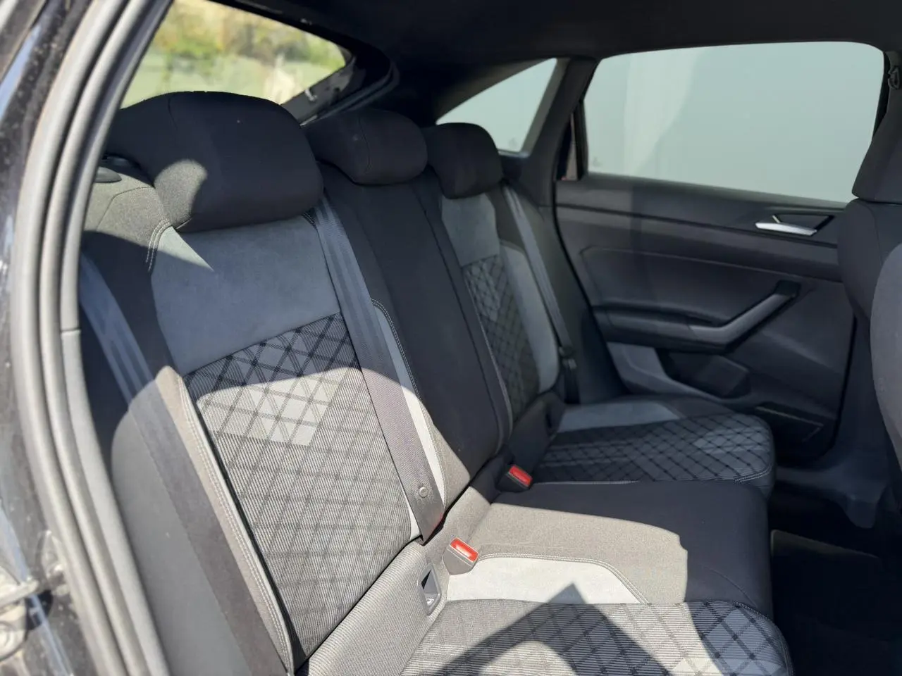 Vue côté droit de la banquette arrière noire avec sellerie tissu R-Line à motifs losanges dans un Volkswagen Taigo 2025.