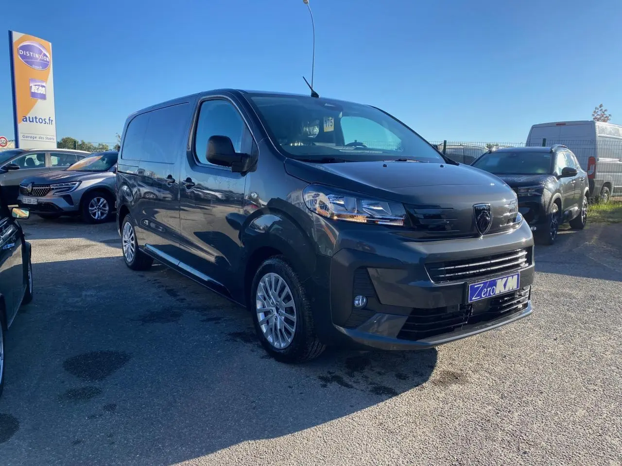 Peugeot Expert Fourgon gris titane vu en 3/4 avant droit avec jantes tôle et calandre noire brillante.