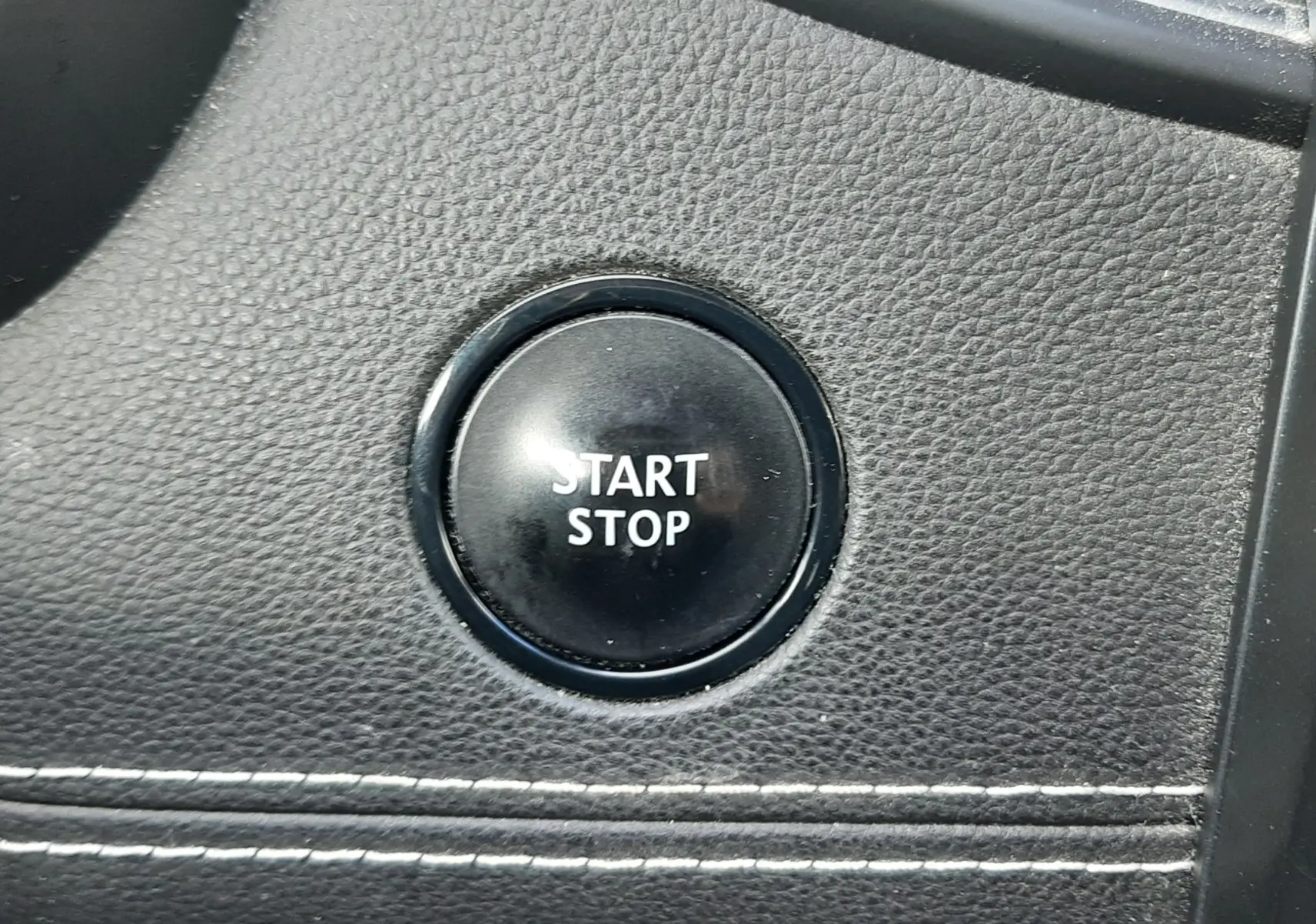 Gros plan sur la commande audio au volant du Renault Scénic IV 2020, finition noire avec boutons de volume et mode.