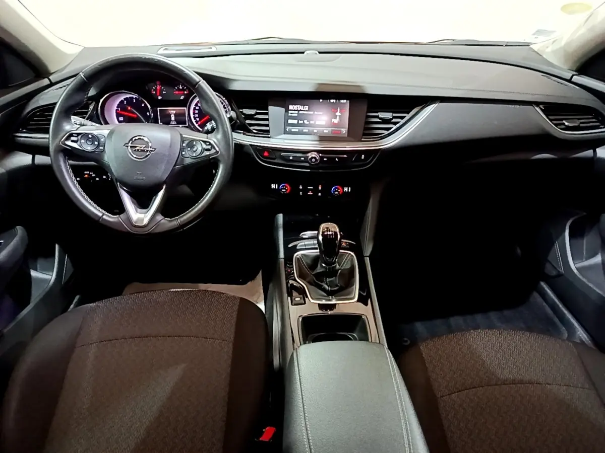 Vue intérieure frontale de l’Opel Insignia 1.6 Diesel 2019, tableau de bord noir avec écran tactile et volant cuir.