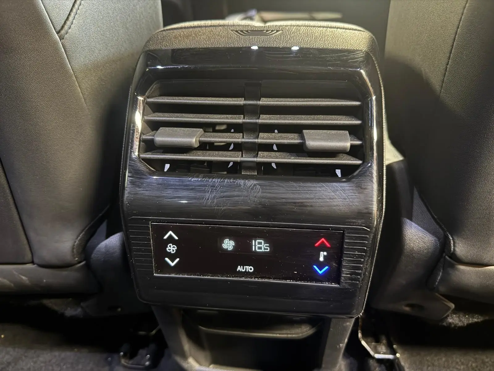 Vue rapprochée de la console arrière du Peugeot 5008 gris, avec commandes de climatisation digitale affichant 18,5°C.