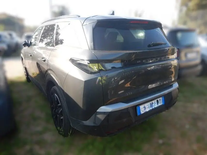 Vue 3/4 arrière droite d'un Peugeot 5008 gris 2025, SUV hybride avec feux arrière étirés et hayon lisse.
