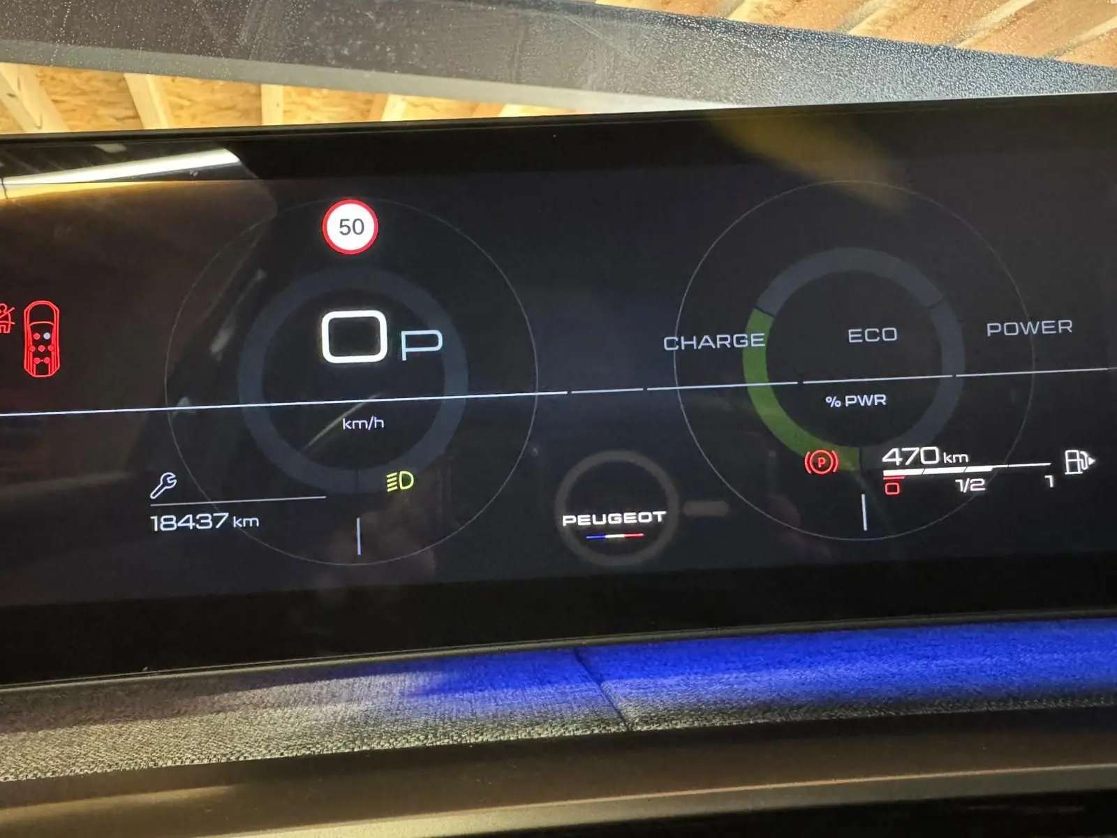 Tableau de bord numérique du Peugeot 5008 gris 2025, affichant vitesse, autonomie et indicateurs hybrides.