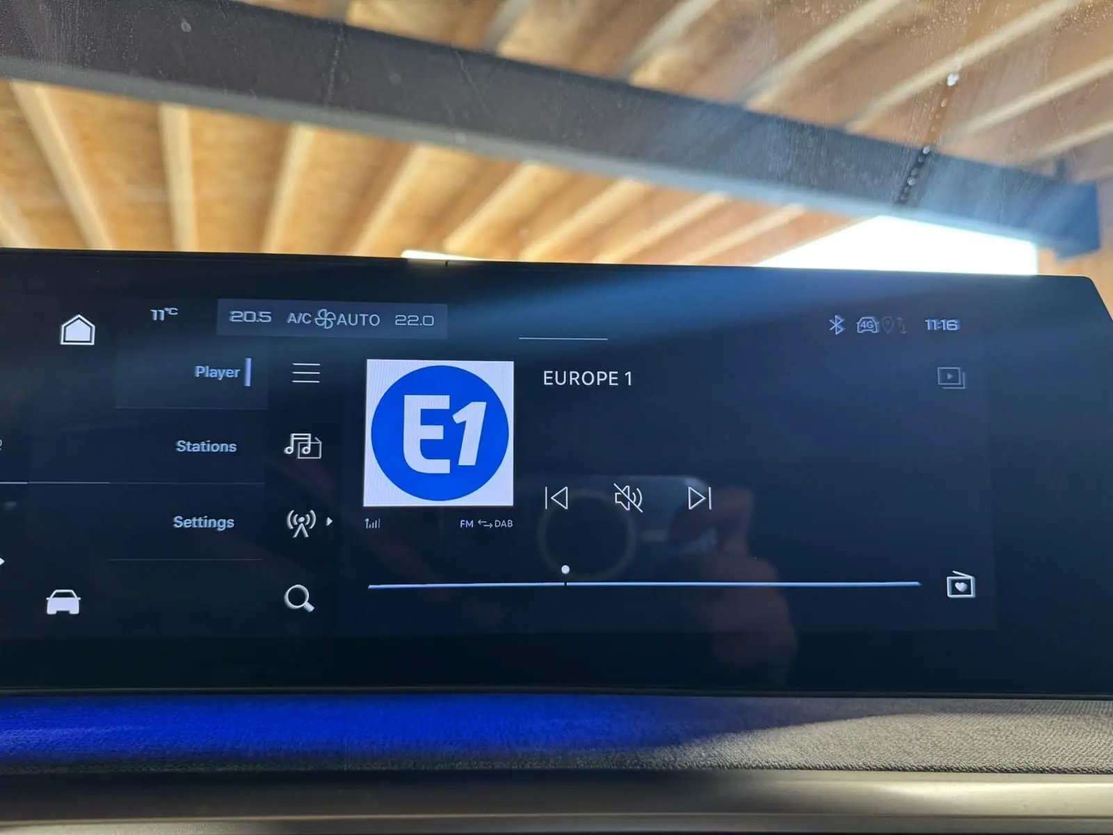 Écran tactile intérieur du Peugeot 5008 gris 2025 affichant la radio Europe 1 avec ambiance lumineuse bleue.