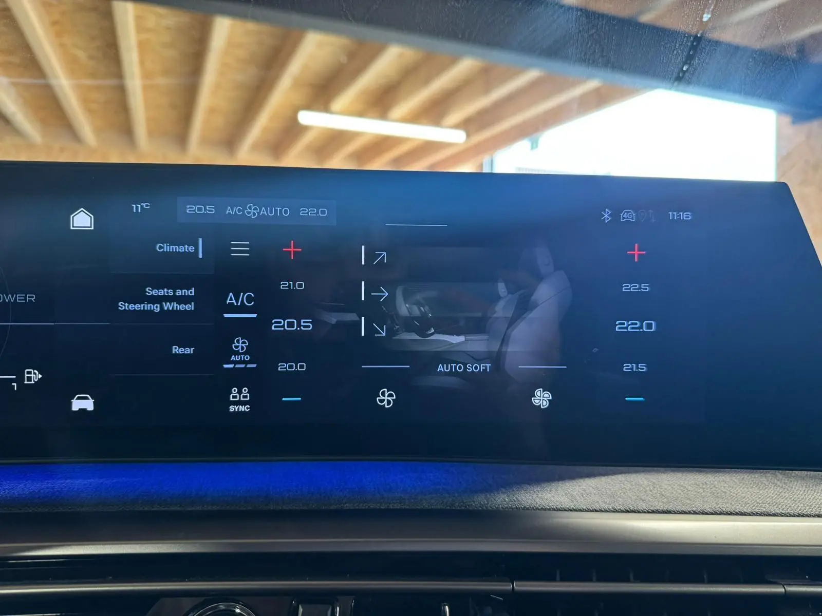 Écran tactile central du Peugeot 5008 gris 2025 montrant les réglages de climatisation avec ambiance lumineuse bleue.