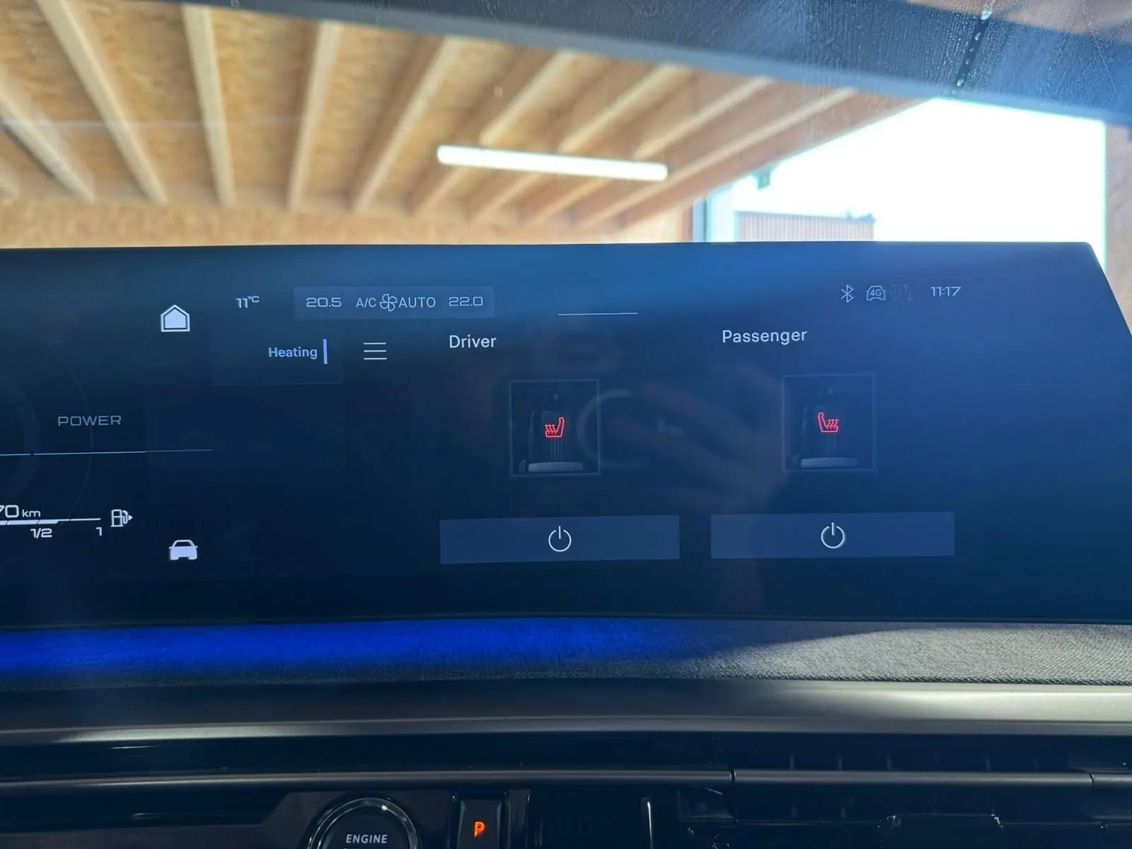 Écran tactile intérieur du tableau de bord du Peugeot 5008 gris 1.2 Hybrid 136 GT, affichant les commandes de chauffage des sièges.