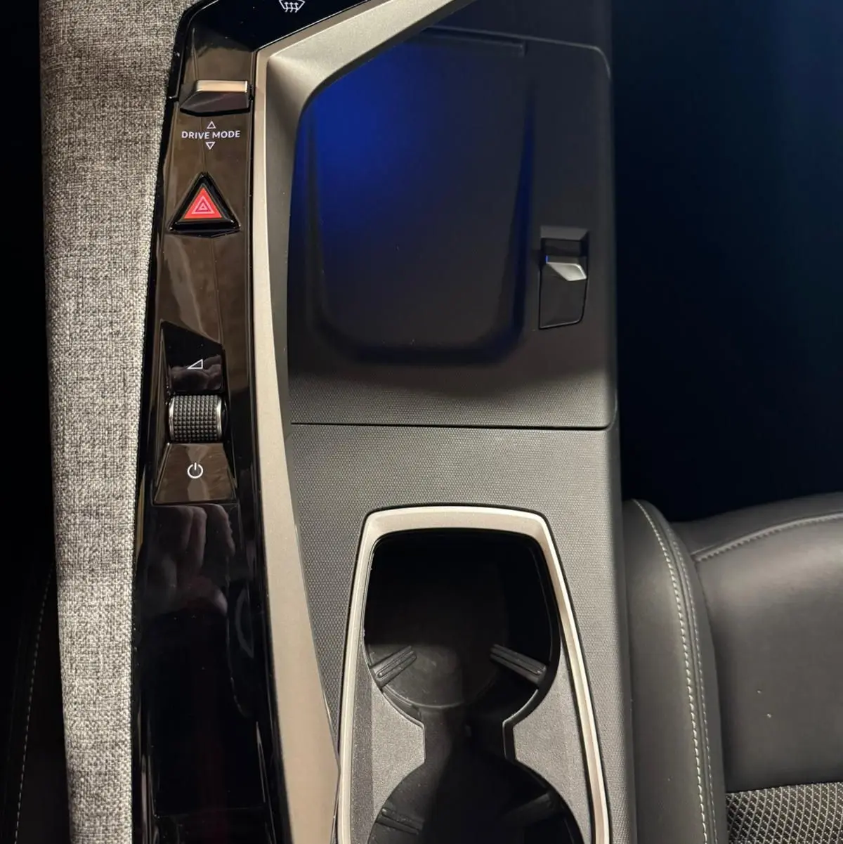 Vue plongeante sur la console centrale noire et grise du Peugeot 5008 1.2 Hybrid 136 GT avec porte-gobelets et commandes tactiles.