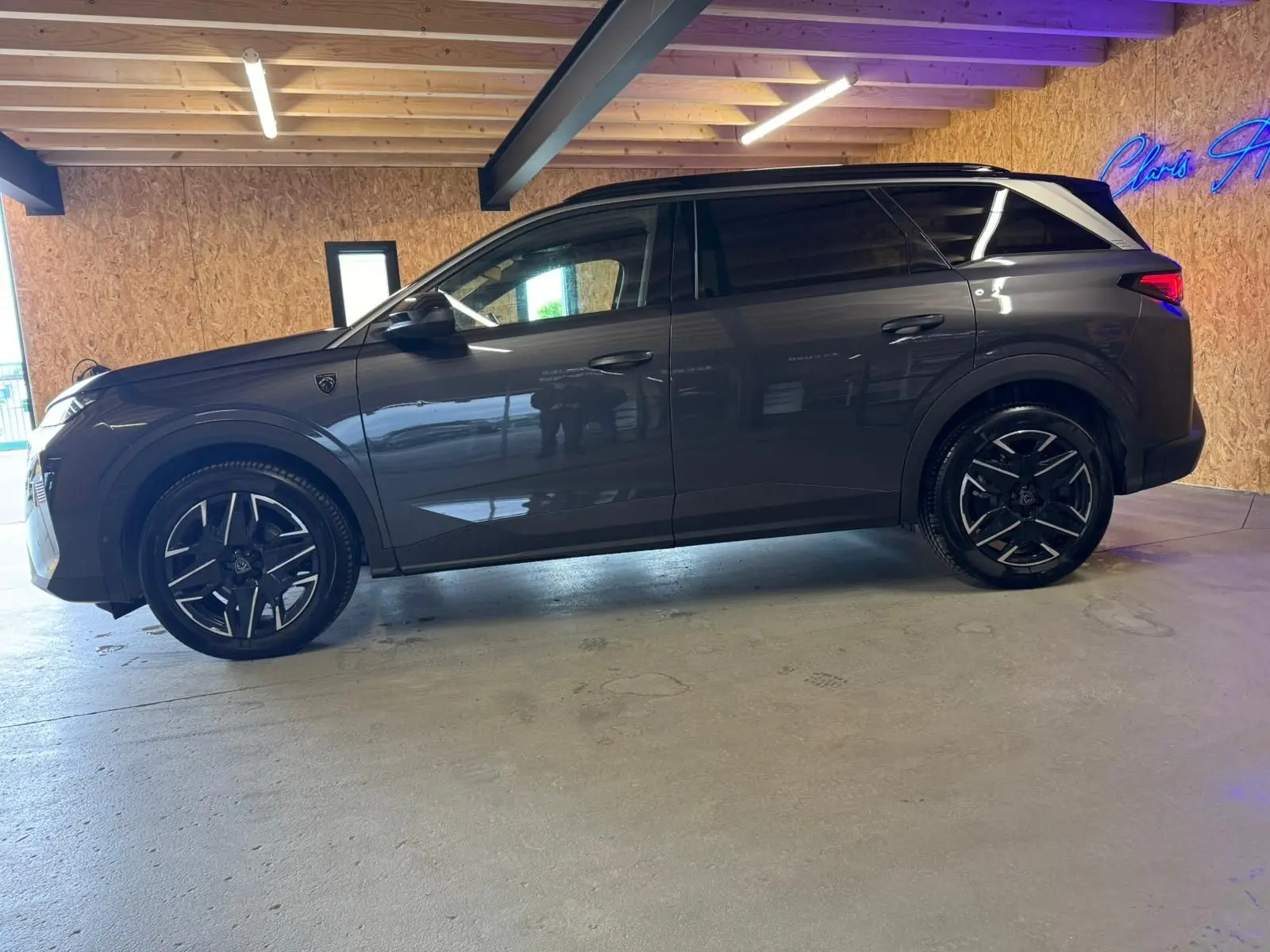 Peugeot 5008 1.2 Hybrid 136 GT gris, vue profil côté gauche, avec jantes alliage noires et toit noir contrasté.