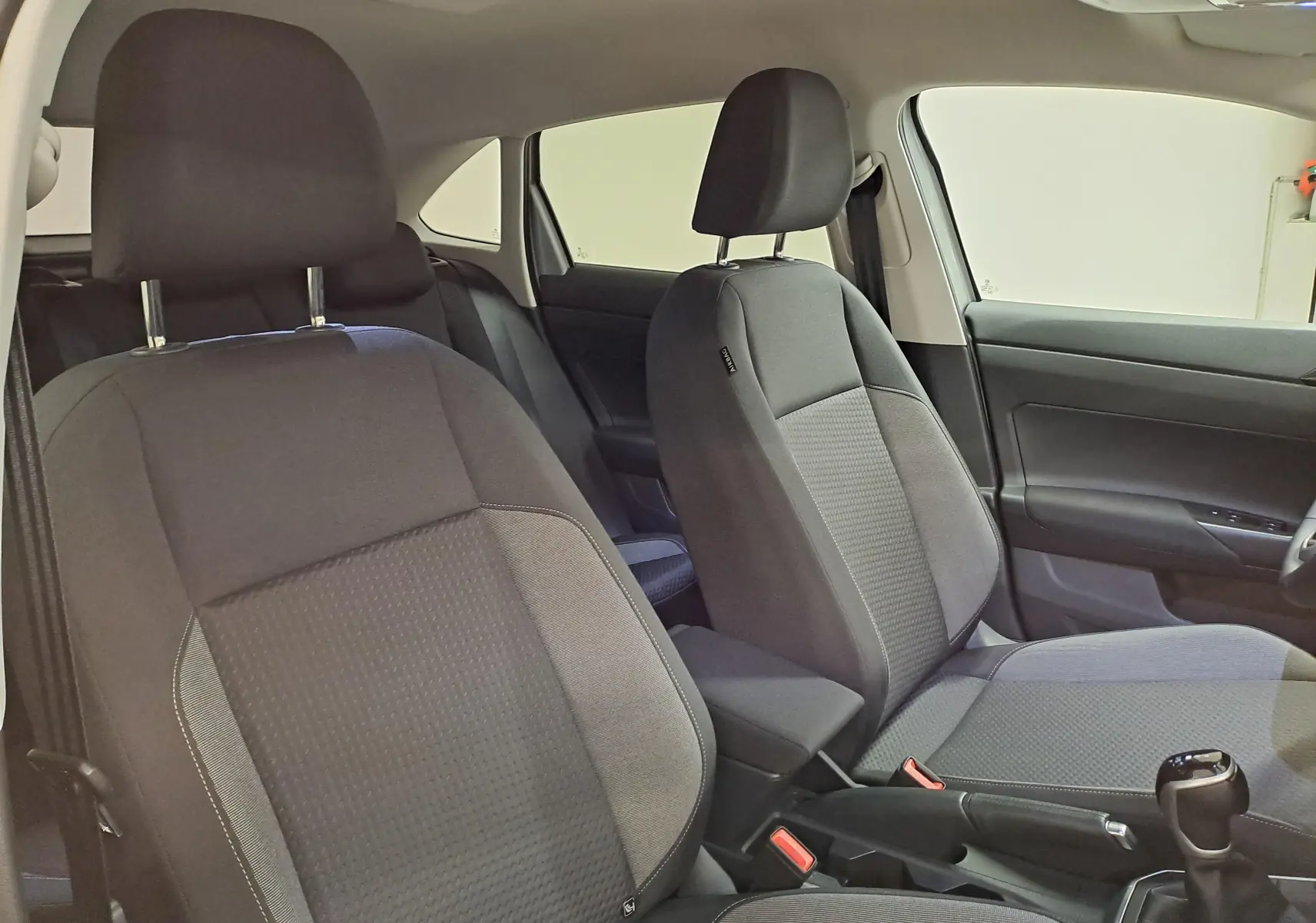 Vue intérieure des sièges avant en tissu gris du Volkswagen Taigo 2025, version 1.0 TSI 116 DSG7 VW EDITION.
