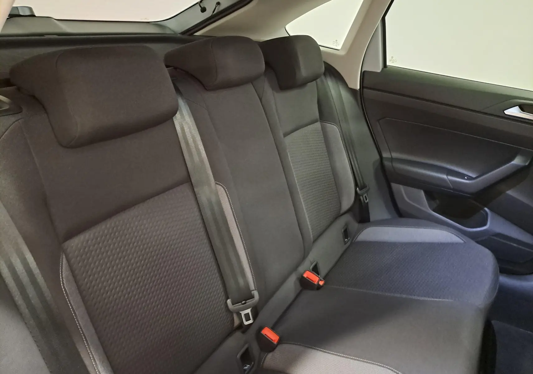 Vue intérieure du siège arrière côté droit du Volkswagen Taigo 2025 avec sellerie noire et ceintures de sécurité visibles.