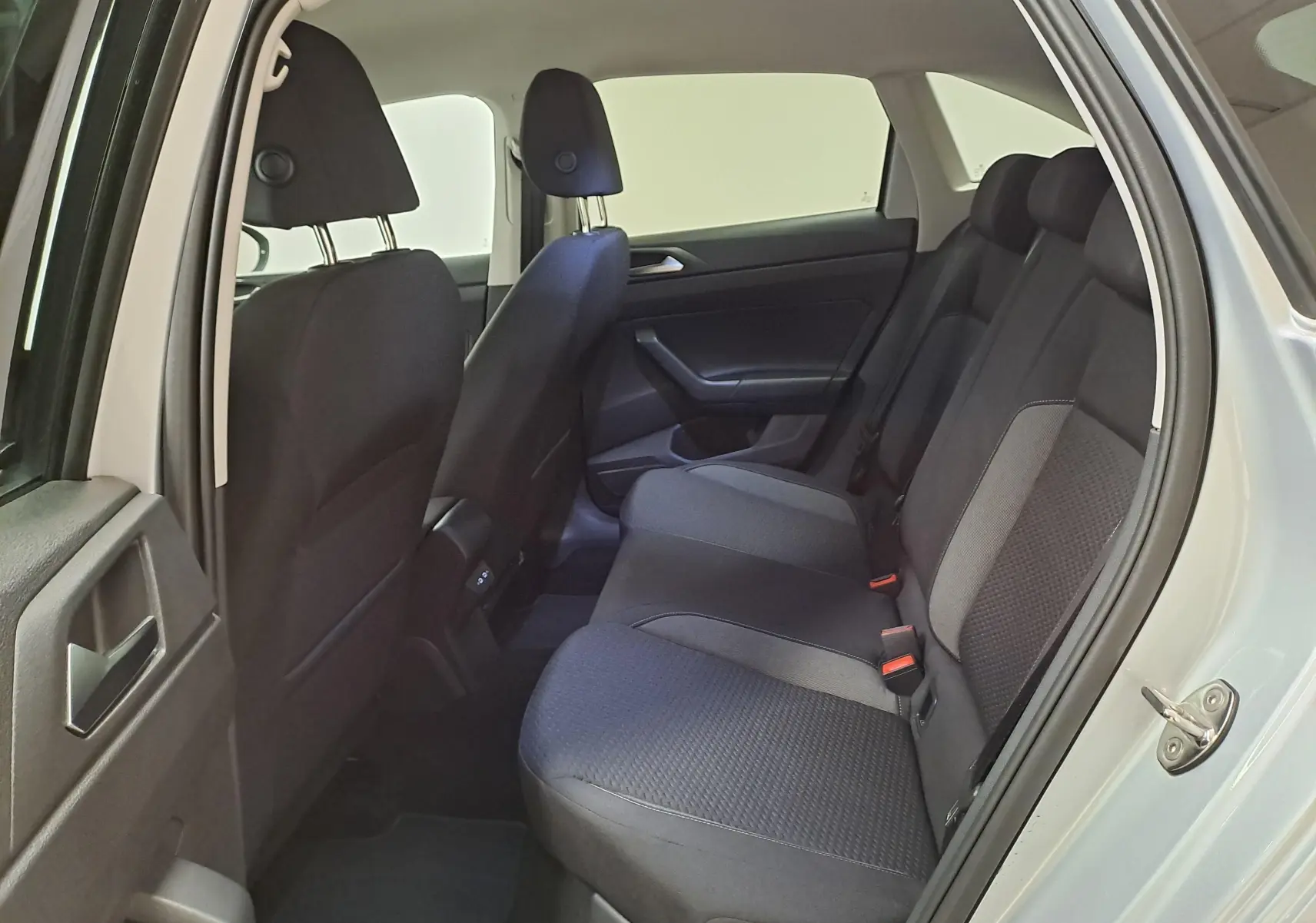 Vue côté droit de l'habitacle arrière du Volkswagen Taigo 2025 en Reflet d'Argent, sièges tissu noir et gris.
