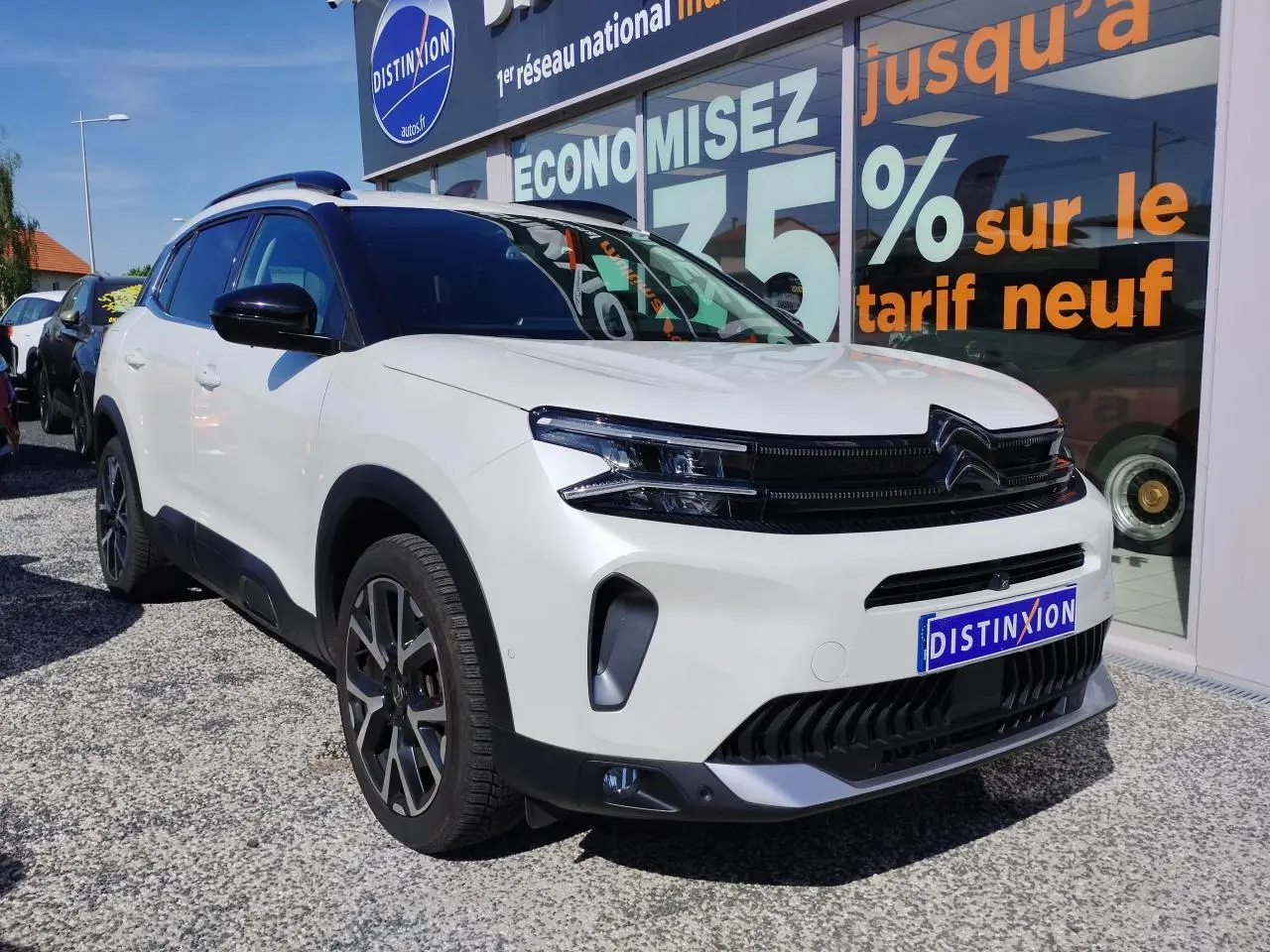 Vue 3/4 avant droit d'un Citroën C5 Aircross blanc nacré avec toit noir et calandre noire brillante.