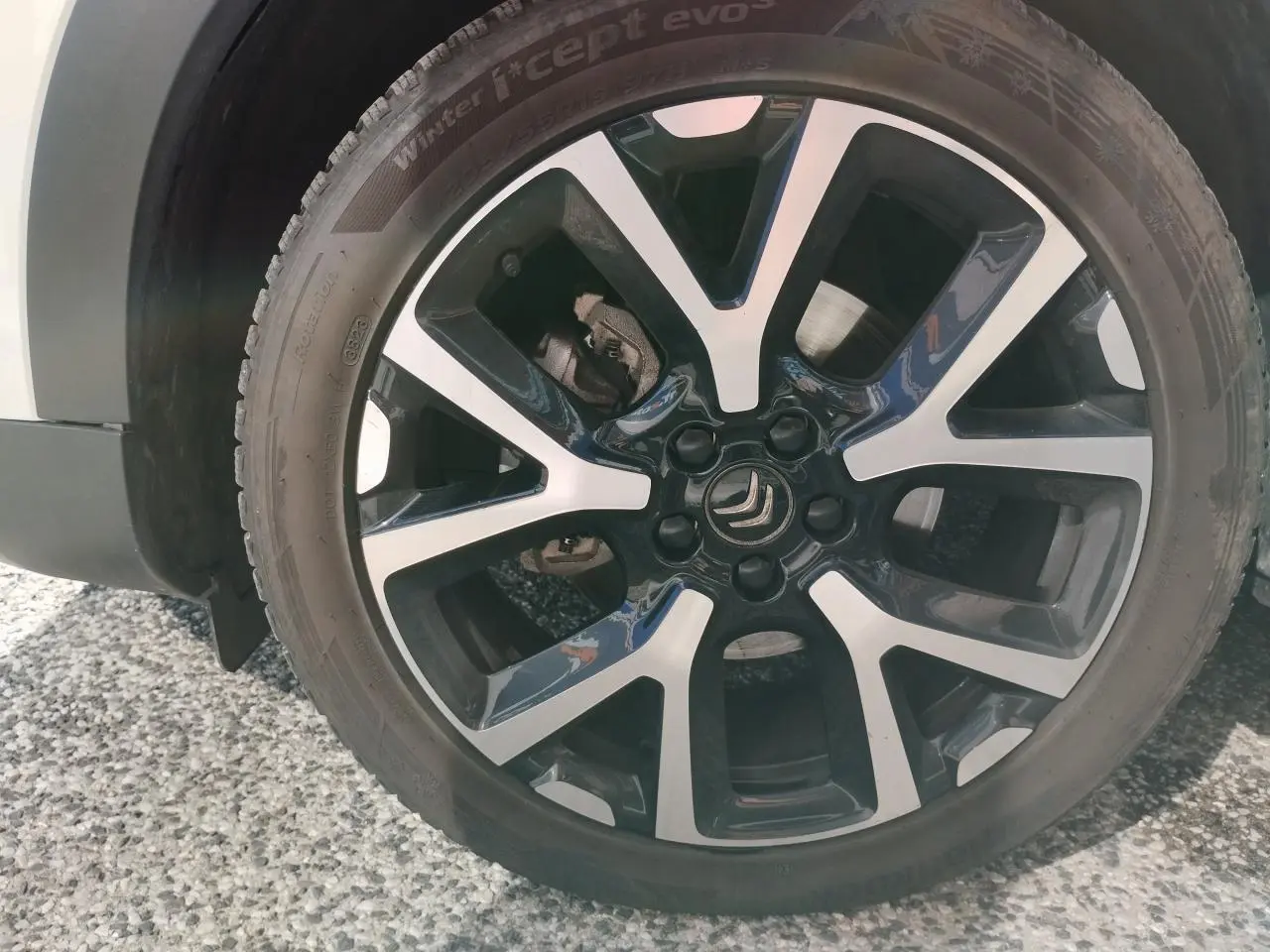 Gros plan sur la jante alliage bi-ton noire et argentée du côté avant droit du Citroën C5 Aircross blanc nacré.