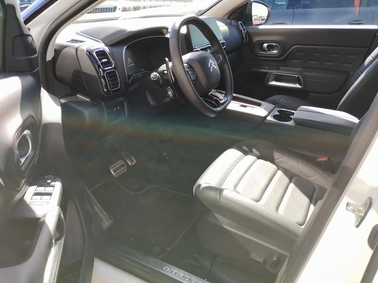 Vue intérieure côté conducteur du Citroën C5 Aircross blanc nacré, volant cuir et sièges Advanced Comfort noirs.
