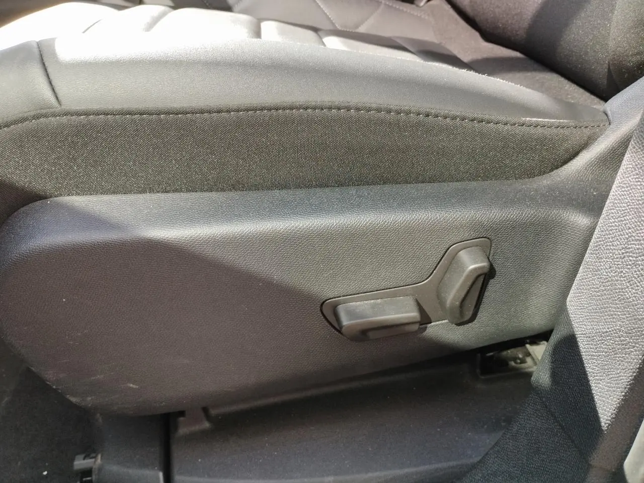 Détail côté gauche du siège avant en cuir noir du Citroën C5 Aircross 2022 avec commandes de réglage électrique.