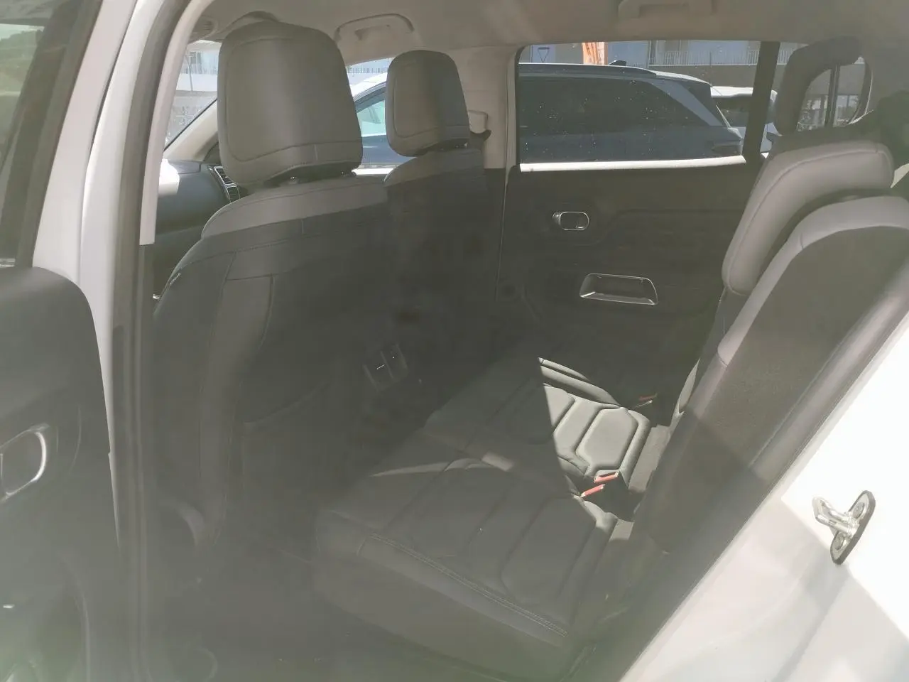 Vue intérieure côté droit des sièges arrière noirs en cuir du Citroën C5 Aircross blanc nacré avec toit noir.