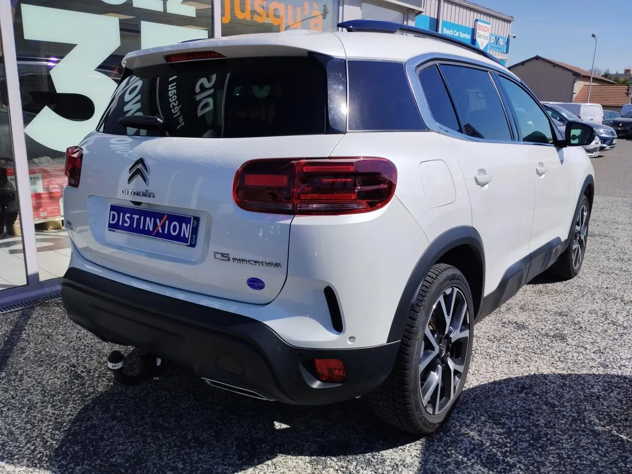 Vue 3/4 arrière droite du Citroën C5 Aircross blanc nacré avec toit noir et attelage col de cygne démontable.