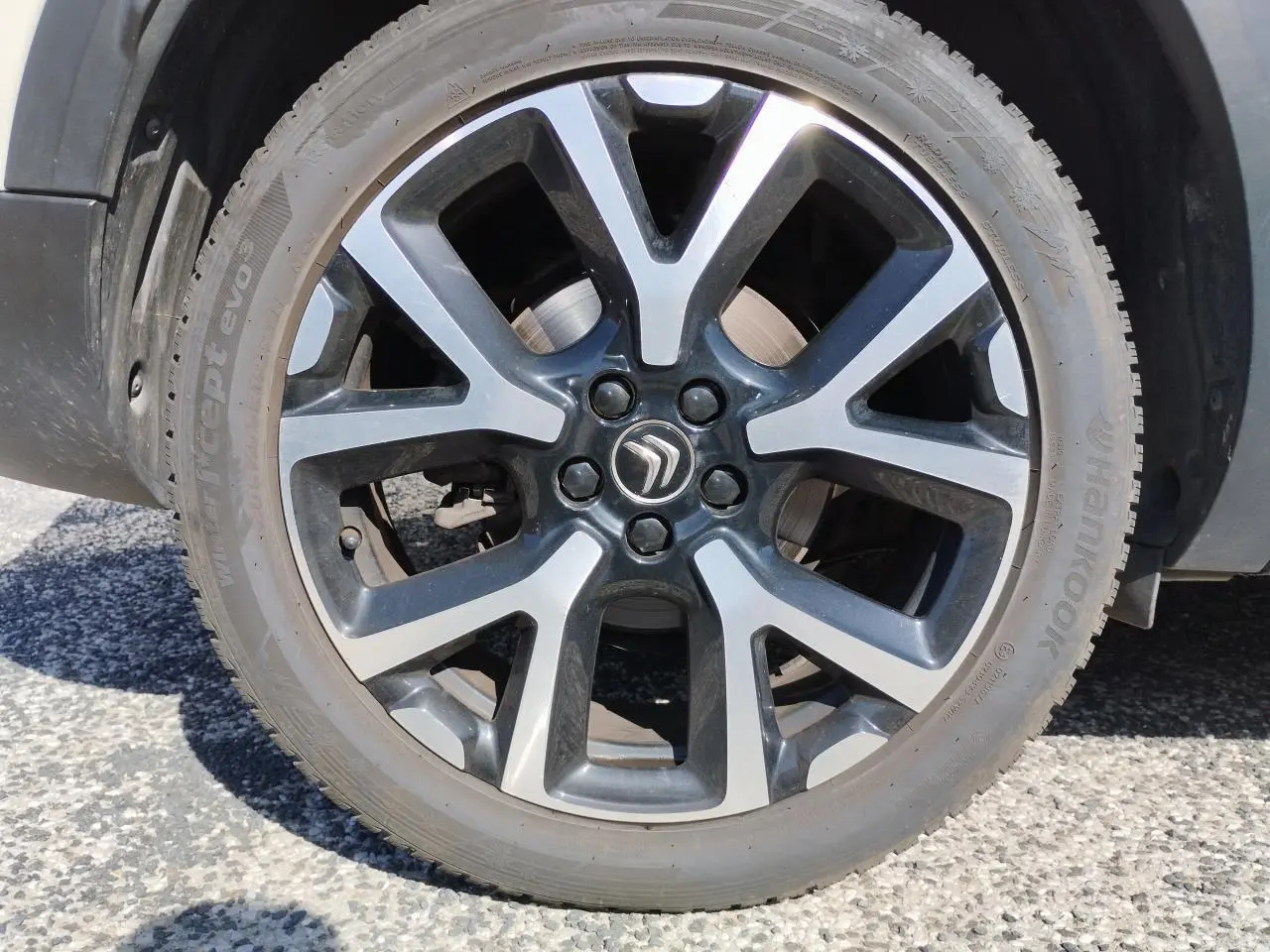 Gros plan sur la jante alliage bi-ton noire et argentée du Citroën C5 Aircross blanc nacré, roue avant droite.