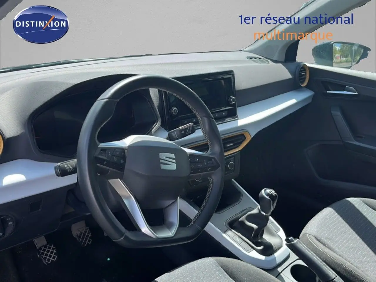 Vue intérieure du poste de conduite de la SEAT Arona 2025, volant multifonction et levier de vitesses manuelle visibles.