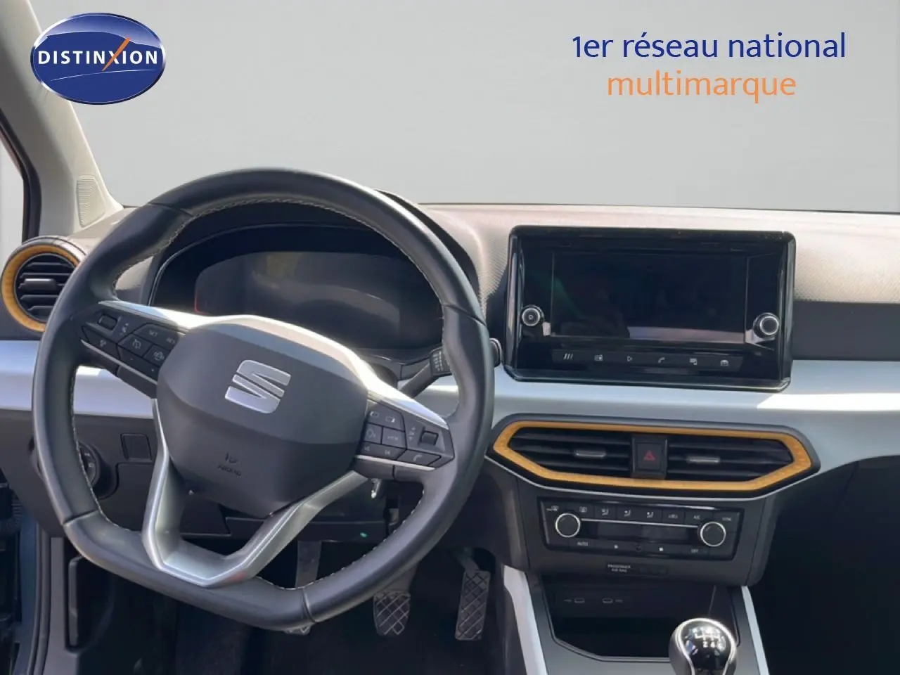 Intérieur du SEAT Arona 2025 vu de face, volant multifonction et écran tactile avec cadre décoratif bois clair.