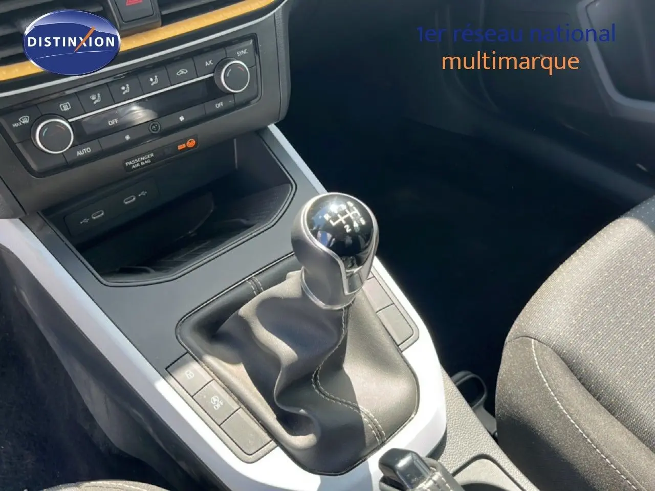 Gros plan sur la console centrale du SEAT Arona 2025 avec levier de vitesse manuel et commandes de climatisation.