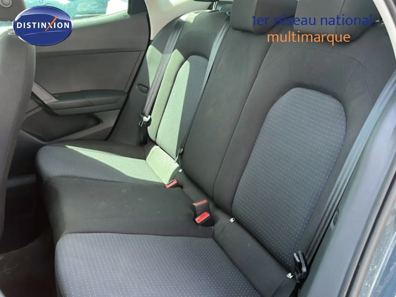 Vue intérieure de la banquette arrière d'une SEAT Arona 2025 avec sellerie tissu gris et noir, côté droit visible.