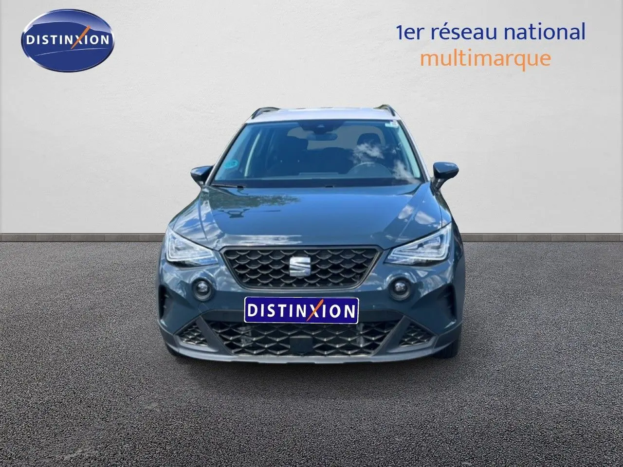 Vue frontale d'un SEAT Arona bleu Fjord avec toit blanc, calandre noire et phares LED allumés.